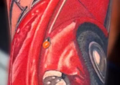 Farbiges Bein Tattoo - Ein roter VW Käfer